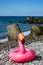 Children`s lifeline on the beach. Bright children`s inflatable circle lying on the Ground on the beach. Lifebuoy pink in the sha