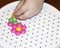 Children`s mosaic. the child lays a flower out of a colored plastic mosaic. the child`s hand holds a bright plastic mosaic piece