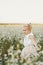 Children`s portrait of a girl.beautiful girl in a flowering field. Young girl play in spring dandelion field