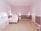 Children`s room for girls in classic style in light pink colors and white furniture