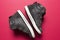Children`s shoes made of black leather on a pink background.