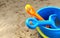 Children`s shovel and rake and bucket lie on the sand