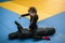 Children`s sports activity in the gym. The child beats the training dummy with his hands. A little girl sits on top on a training