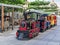 Children`s summer attraction locomotive with cars on a city street