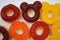 Children\\\'s sweets in the form of multi-colored donuts, chewable, gelatin sweets are located on a white background.