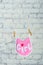 Children`s toddler pink saliva on a rope on a white brick wall background.