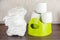 Children`s toilet pot green, nappies and toilet paper, the concept of the baby`s transition from diapers to the toilet.