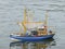 Children`s toy of fishing boat is floating on the lake. Ship model