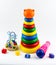 Children`s toys on a white background. Pyramid, microphone, puzzle