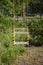 Children`s wooden swing on the ropes hang on the background of park greenery