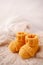 Children`s yellow knitted booties on a light gentle background. The concept of expecting a child, motherhood, parenthood