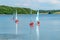 Children sailing boats on reservoir lake.