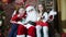 Children with Santa Claus sitting on a chair and waving their hands