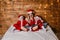 Children in santa costumes read with mom book