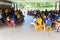 Children in school assembly under cover of roof