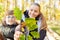 Children of a school class with an oak leaf at tree research