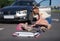 Children scooter lying on background of injured little girl and woman driver of car closeup