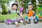 Children scooterists rest sitting on curb of