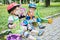 Children scooterists rest sitting on curb of