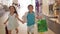 Children shopping, joyful little boy with girl with lots of packages running holding hands after purchases