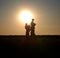 Children on the shoulders of parents go summer evening