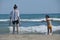 Children, siblings playing on the sea shore. They jumping in the waves