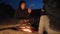 Children silhouette kids teen sit by the fire eating popcorn at night campfire. travel hiking adventure camping