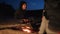 Children silhouette kids teen sit by the fire eating popcorn at night campfire. travel hiking adventure camping