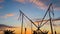 Children silhouettes are jumping on bungee trampoline against sunset sky