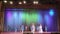 Children sing a song on stage at a festive event.