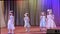 Children sing a song on stage at a festive event.