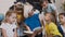 Children sit on floor on the pillows as teacher reads to them interesting book in class at elementary school or