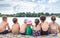 Children sit by the river and eat ice cream