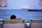 Children, sitting on beach, watching lighted ship in the ocean