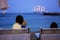 Children, sitting on beach, watching lighted ship in the ocean