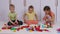 Children sitting on carpet in playroom and playing with constructor lego bricks