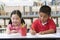 Children sitting at desk and writing in classroom