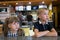 Children sitting in fast food restaurant behind empty table waiting for food