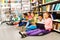 Children sitting on floor in library and studying