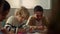 Children sitting at round table in classroom. Students drawing in notebooks