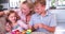 Children Sitting On Sofa With Mother Eating Easter Eggs