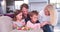 Children Sitting On Sofa With Parents Eating Easter Eggs