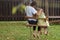 Children sitting on a swing in the garden. older brother hugging little sister