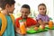 Children sitting at table and eating healthy food during break