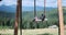 Children sitting on traditional wooden swing