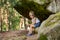 Children, sitting on unique eroded sandstone rock formation in Czech Republic