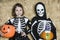 Children In Skeleton Costumes Holding Jack-O-Lanterns