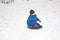 Children are sledding down the hill in snow