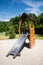 Children slide in green garden with blue sky