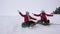 Children slides in snow on an inflatable snow tube and waves hand. Happy girls slides through snow on sled. kids playing